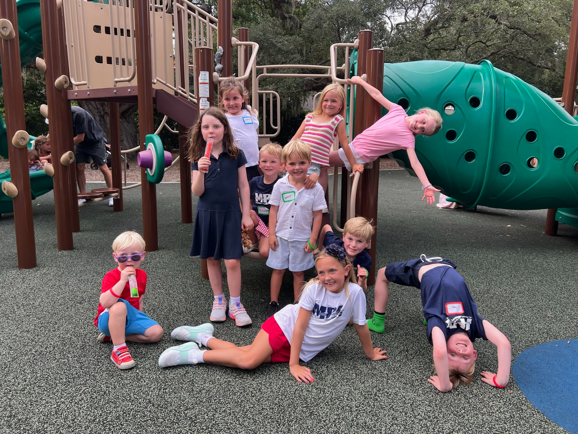 A group of MPA students posing on the playground with popsicles at the Kindergarten Meet-Up