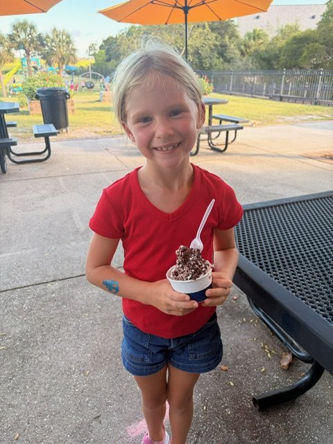 A student smiling with a cup of ice cream from the Mister Softee truck