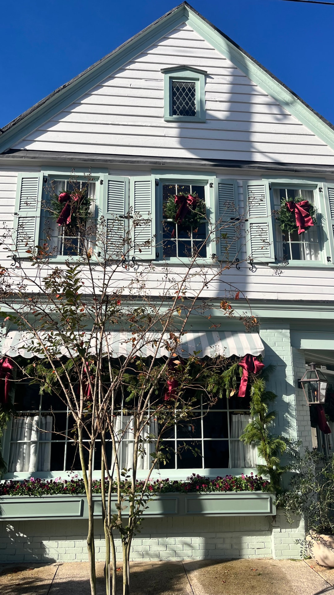 A MPA PTA holiday wreath with a red bow displayed on a home's front windows