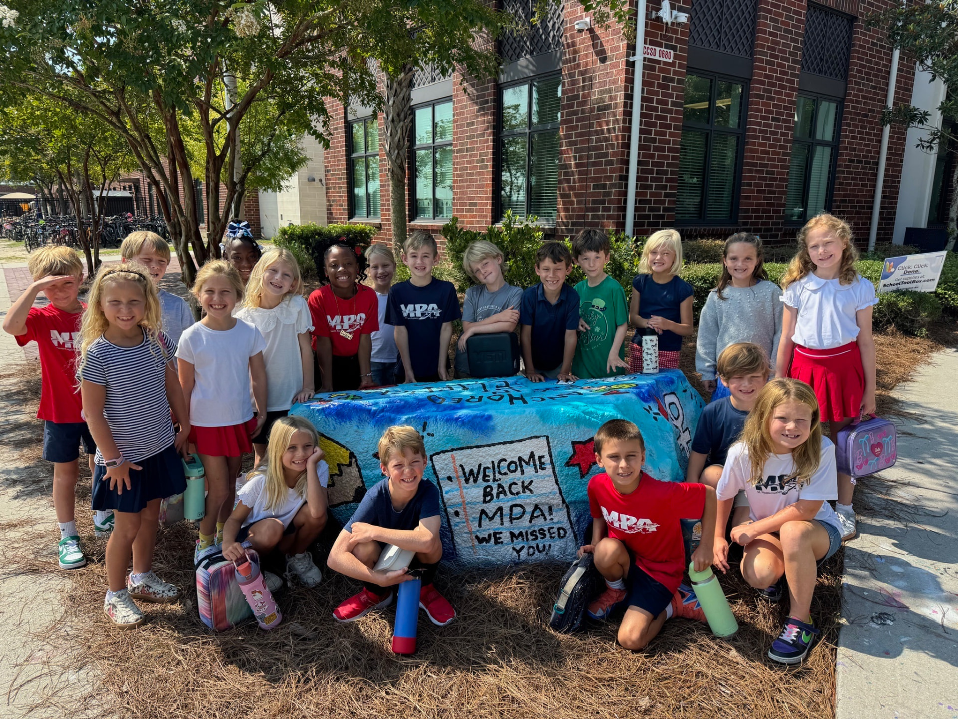 MPA students gathered around the painted Spirit Rock reading Welcome Back MPA, We Missed You