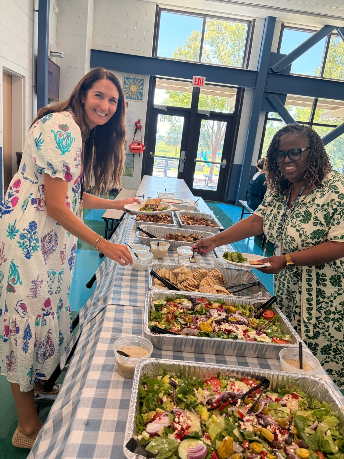 MPA staff smiling at a catered teacher appreciation lunch buffet